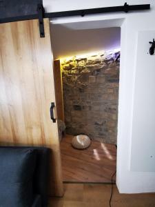 una puerta abierta a una habitación con una pared de piedra en Second chance apartment en Choteč