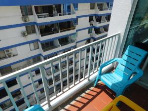 einem blauen Stuhl auf einem Balkon mit einem Gebäude in der Unterkunft Excalibur By DANP in Santa Marta
