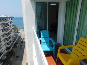 einen Balkon mit 2 blauen Stühlen und Meerblick in der Unterkunft Excalibur By DANP in Santa Marta