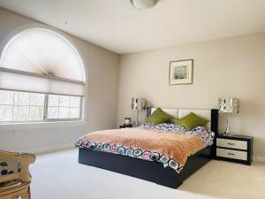 a bedroom with a bed and an arched window at SUMMER HOME in Vancouver