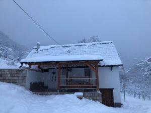 a small house covered in snow with a roof at Kuća za odmor Ravančić 
