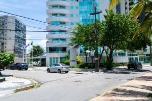 a street with cars driving down a street with a tall building at 202 Flat Beira Mar Av Boa Viagem in Recife