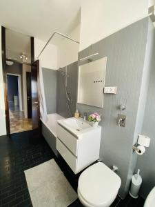 bagno con servizi igienici bianchi e lavandino di Milano relax family house a Brugherio