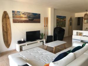 sala de estar con sofá blanco y TV en Apartamento con piscina - Tossa - Magníficas vistas al mar, en Girona