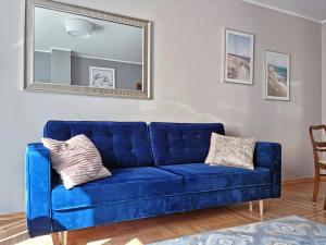 niebieską kanapę w salonie z lustrem w obiekcie CLASSY APARTMENTS - Gdynia - Słoneczny w mieście Gdynia