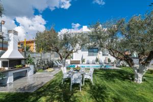 a garden with a table and chairs and a pool at Royal View Villa - Private Pool & Hot Tub in Zakynthos Town
