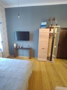 a bedroom with a bed and a dresser and a television at 550 метров до моря in Liepāja