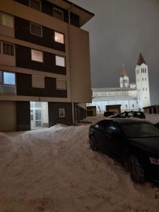 un coche estacionado al lado de un edificio en la nieve en Studio Apartman Maša Kupres en Kupres