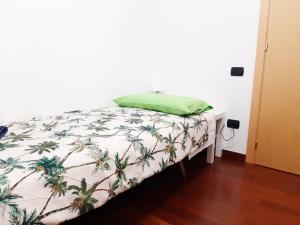 a bed with a green pillow on top of it at Tukasa in Cittadella