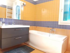 een badkamer met een bad, een wastafel en een spiegel bij Tukasa in Cittadella