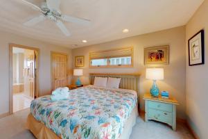 a bedroom with a bed and a ceiling fan at Sand Goodies PI128 in Corolla