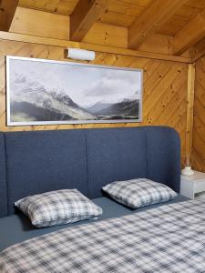 Zimmer mit zwei Kissen auf einem Bett mit einem Bild in der Unterkunft Chalet, Bagnes, Suisse in Le Châble
