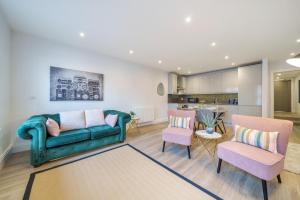 ein Wohnzimmer mit einem grünen Sofa und 2 Stühlen in der Unterkunft Smart Living by Lawsons in Windsor