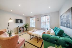 ein Wohnzimmer mit einem grünen Sofa und Stühlen in der Unterkunft Smart Living by Lawsons in Windsor