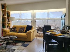 a living room with a yellow couch and a table at Apartaments Font del Cirerer in Sant Hilari Sacalm