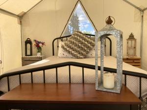 a bedroom with a bed with a candle on a table at Tentrr Signature - Hidden Acres Orchards in Mead