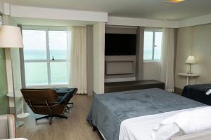 Pokój hotelowy z łóżkiem, krzesłem i oknem w obiekcie 2906 Cobertura Beira Mar Av Boa Viagem w mieście Recife +39 zdjęć