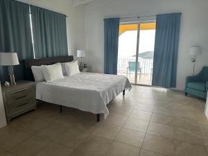 a bedroom with a bed with blue curtains and a balcony at The Mafolie Hotel in Mafolie