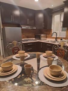 a kitchen with a table with plates and cups on it at Departamento Orange in Ensenada