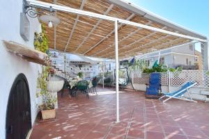 eine Terrasse mit Markise sowie einem Tisch und Stühlen in der Unterkunft L'Arco in Terrasini