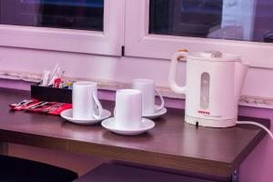 a table with two cups and a tea kettle at Affittacamere The Tramp in La Spezia