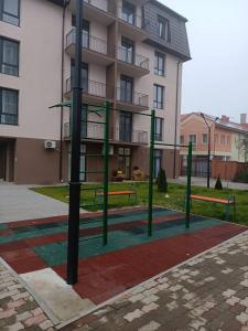 een park met banken voor een gebouw bij Apartments Domovik Myru St. 11s/21 in Mukacheve