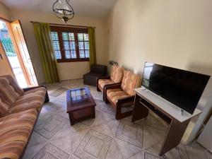 sala de estar con sofás y TV de pantalla plana. en House CÉNTRICA en Villa Carlos Paz