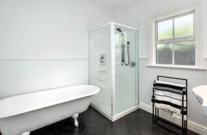 La salle de bains blanche est pourvue d'une baignoire et d'un lavabo. dans l'établissement Karoo House, à Greytown