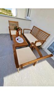 un groupe de chaises et une table avec une plaque dans l'établissement Apartment Ane 2, à Tisno