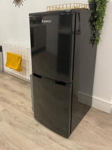 un refrigerador negro sentado junto a una pared en Luxurious New 2 Bed Apartment in Burnley, Lancashire, en Burnley