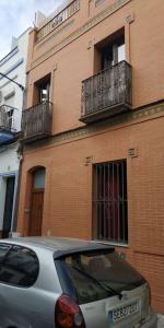 een zilveren auto geparkeerd voor een bakstenen gebouw bij Fabuloso apartamento en Triana in Sevilla