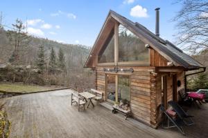 a log cabin with a picnic table on a deck at Srub Pod Lípou - Skryje 