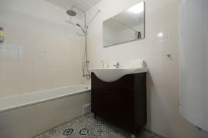 La salle de bains est pourvue d'un lavabo, d'une baignoire et d'un miroir. dans l'établissement Ola Lisbon – Rato II, à Lisbonne