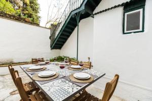 - une table avec des assiettes et des verres à vin sur la terrasse dans l'établissement Ola Lisbon – Rato II, à Lisbonne