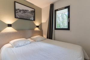 ein Schlafzimmer mit einem weißen Bett und einem Fenster in der Unterkunft MC Tourisme - Splendide & cosy appartement avec piscine, tennis & parking in Le Touquet-Paris-Plage