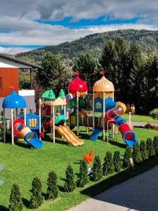 a playground in the grass with a slide at Apartamenty koło Szczyrku A&S Spa - basen, jacuzzi, sauna in Szczyrk