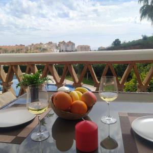 - une table avec un bol de fruits et deux verres de vin dans l'établissement Pueblo Jardín charming Andalusian complex, à Benalmádena