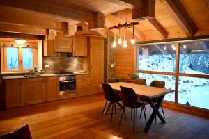 a kitchen with a table and chairs in a cabin at Consulat des Elohim chez Allan et Lili-Peace in Crans-Montana