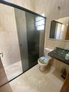 a bathroom with a shower and a toilet and a sink at Apartamento Bela vista II in Guaratinguetá