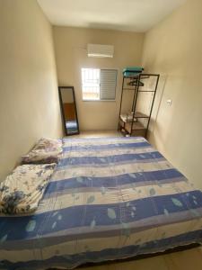 a bedroom with a bed with a blue comforter at Apartamento Bela vista II in Guaratinguetá
