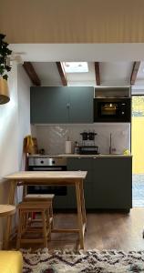 a kitchen with a wooden table and a stove at Estoril Tiny Home 5 Minutes From the Beach in Estoril