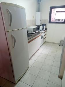 a kitchen with a refrigerator and a stove top oven at Dpto dos dormitorios en Nueva Córdoba in Cordoba