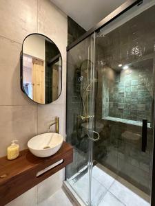 a bathroom with a sink and a glass shower at Estoril Tiny Home 5 Minutes From the Beach in Estoril