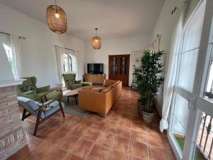 sala de estar con sofá, sillas y TV en Spacious Villa with Exceptional Views in Malaga en Casarabonela