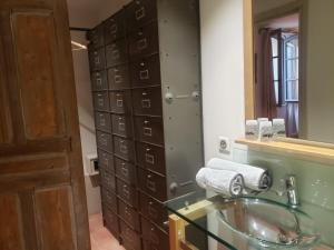 a bathroom with a glass sink and a mirror at La petite hostellerie in Uzès