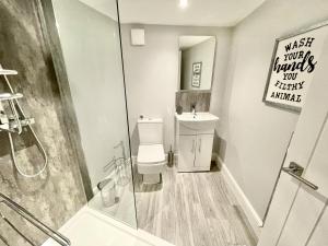 a bathroom with a shower and a toilet and a sink at LYMM LIVING in Warrington