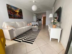 - un salon avec un canapé blanc et un tapis dans l'établissement Jandia Beach Apartment, à Morro del Jable