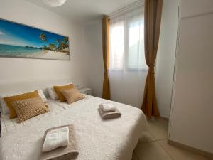 a bedroom with a bed with two towels on it at Jandia Beach Apartment in Morro del Jable