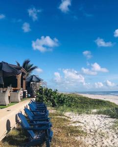 - une rangée de chaises longues bleues sur la plage dans l'établissement Bleu Beach Resort, à Indialantic