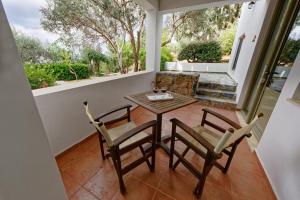 a patio with a table and chairs on a balcony at Mourtzanakis Residence - Traditional Eco Hotel in Achlada in Achlada